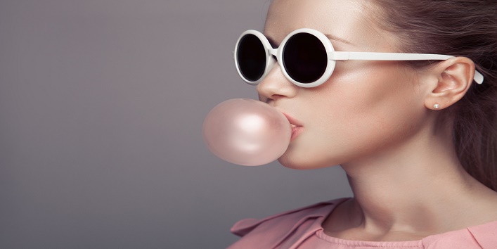 Beautiful blonde woman. Fashion portrait. Blowing bubble gum.