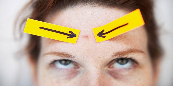 Arrows Pointing to Blemish on Woman's Forehead