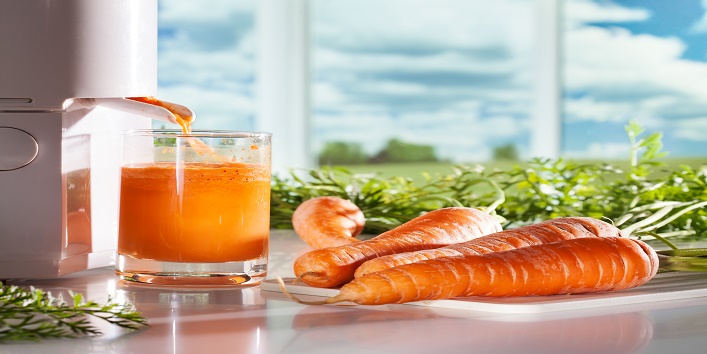 Fresh carrot juicFresh carrot juice and juicer on window backgrounde