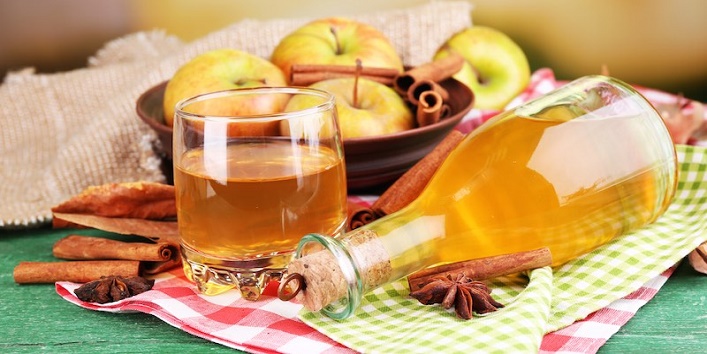 Composition of apple cider with cinnamon sticks, fresh apples